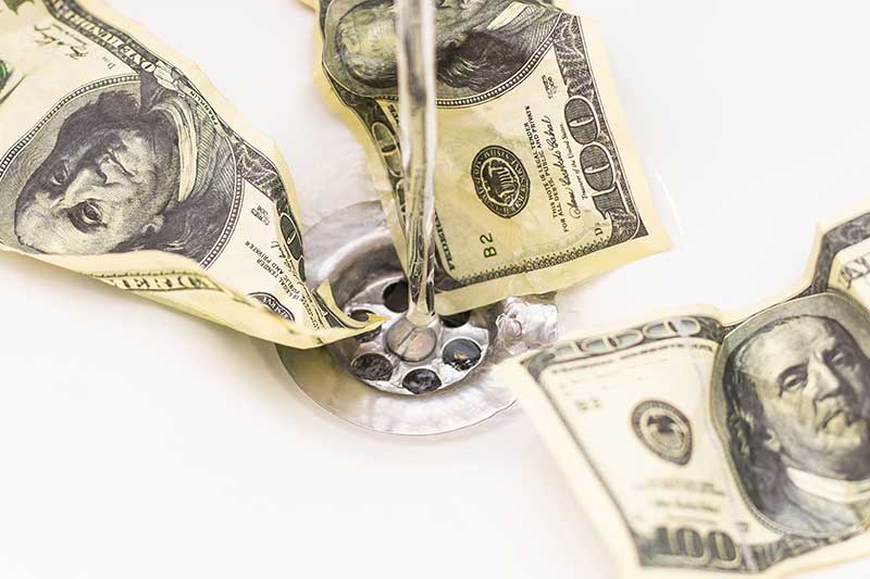hundred dollar bills going down the drain